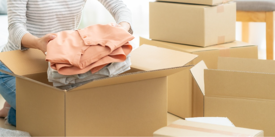 段ボールに荷物をつめる女性